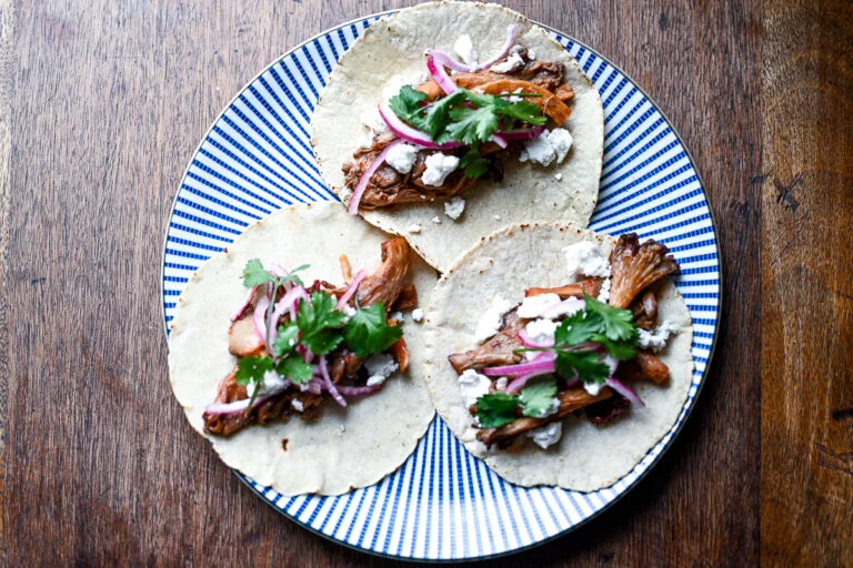 Chipotle Mushroom Tacos topped with cheese and onions