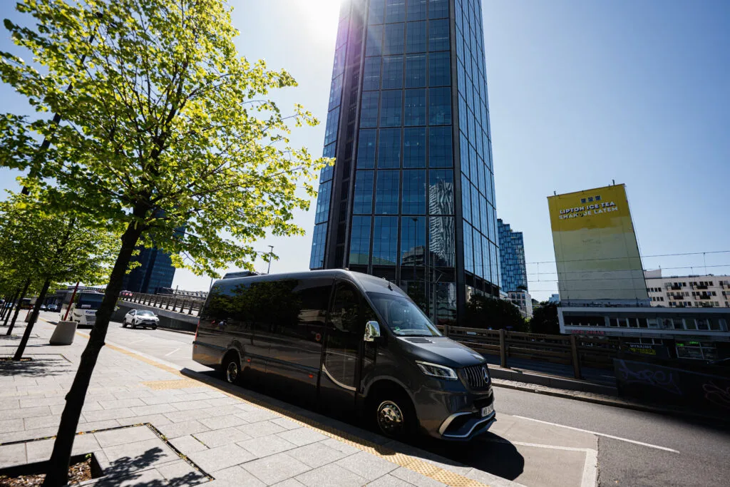 How to Rent a Van Without Breaking the Bank ray Mercedes-Benz Sprinter 519 Bus Factory Luxury Line van on a city street with modern architecture in Warsaw, Poland